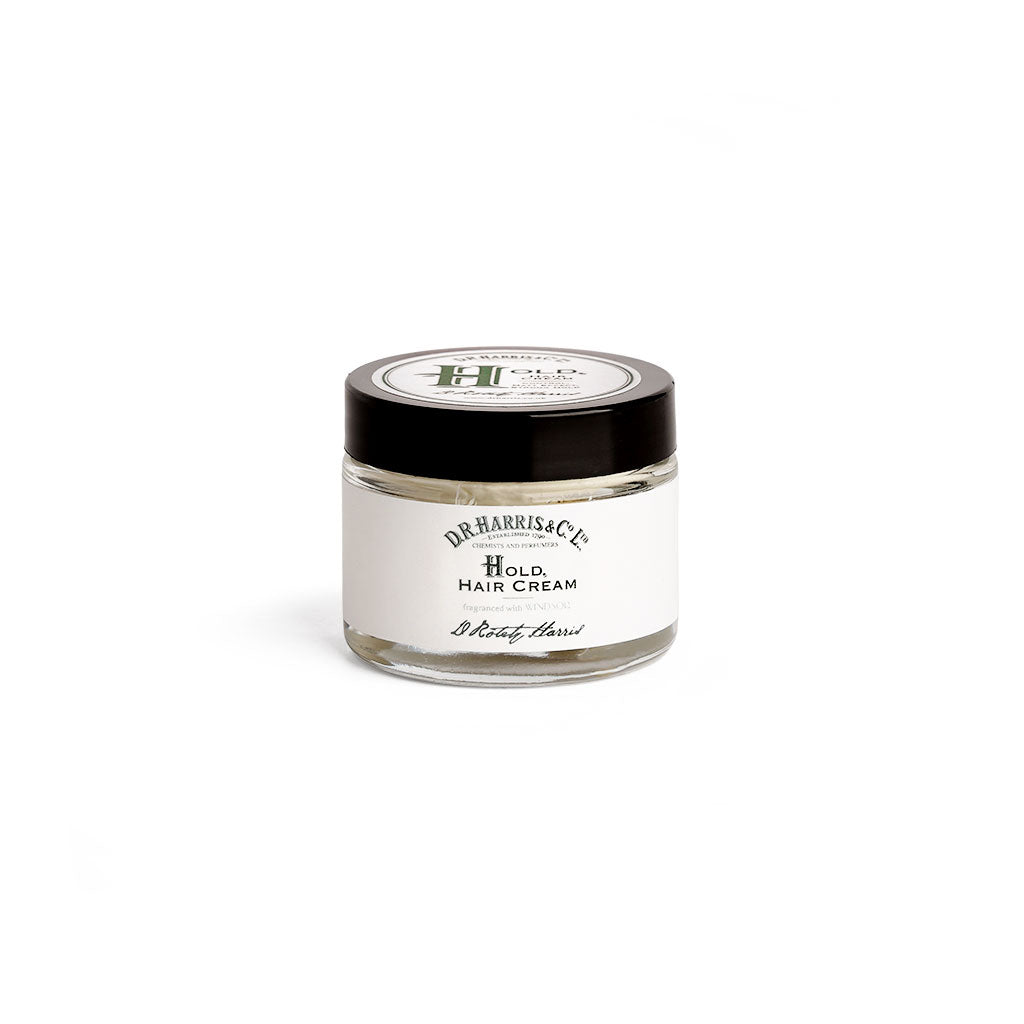 Small tub of D. R. Harris hold hair cream with black screw lid on white background