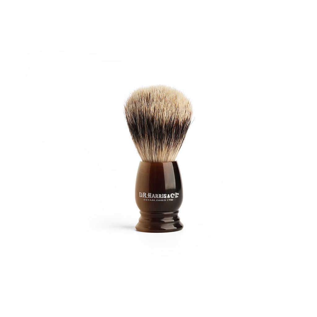 Shaving brush with imitation horn handle and badger bristles on a white background
