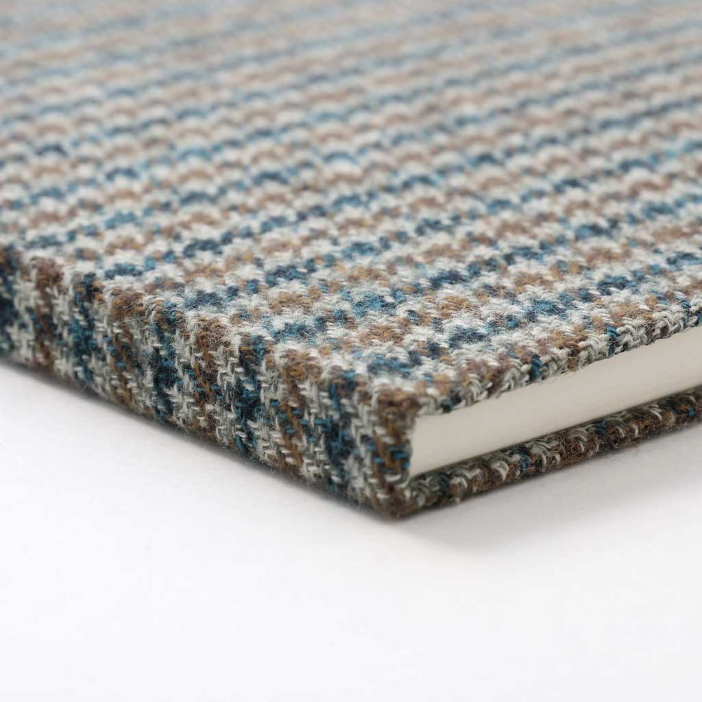 Blue and greenish houndstooth fabric notebook cover on white background