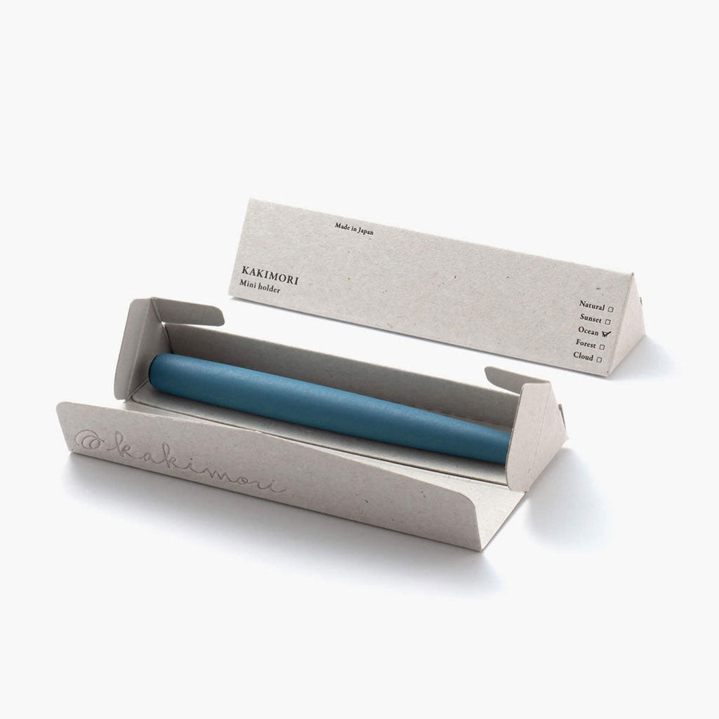 Kakimori mini holder with a blue pen in a cardboard box on a white background