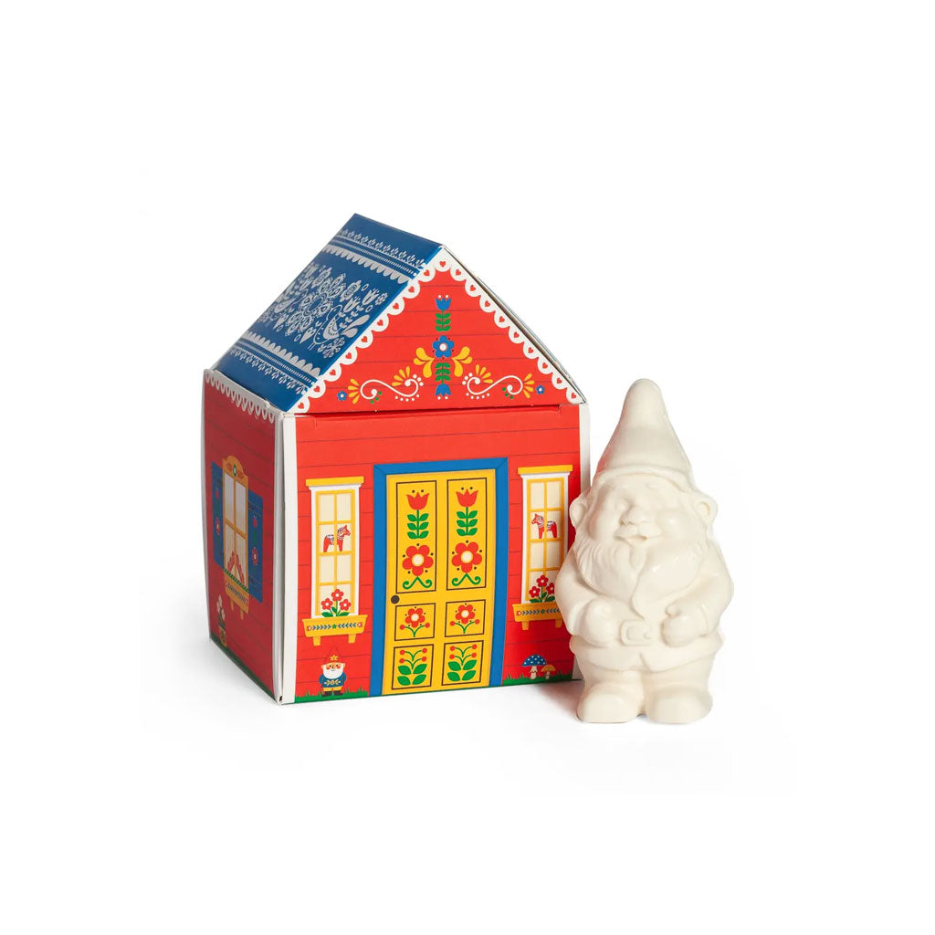 White gnome-shaped soap bar next to decorative red cottage box.