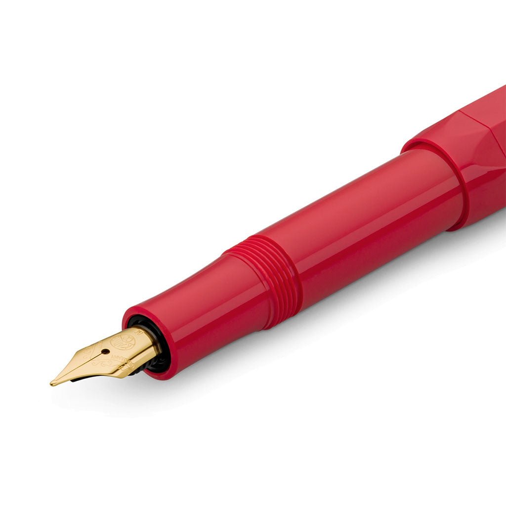 Red fountain pen with gold nib on a white background