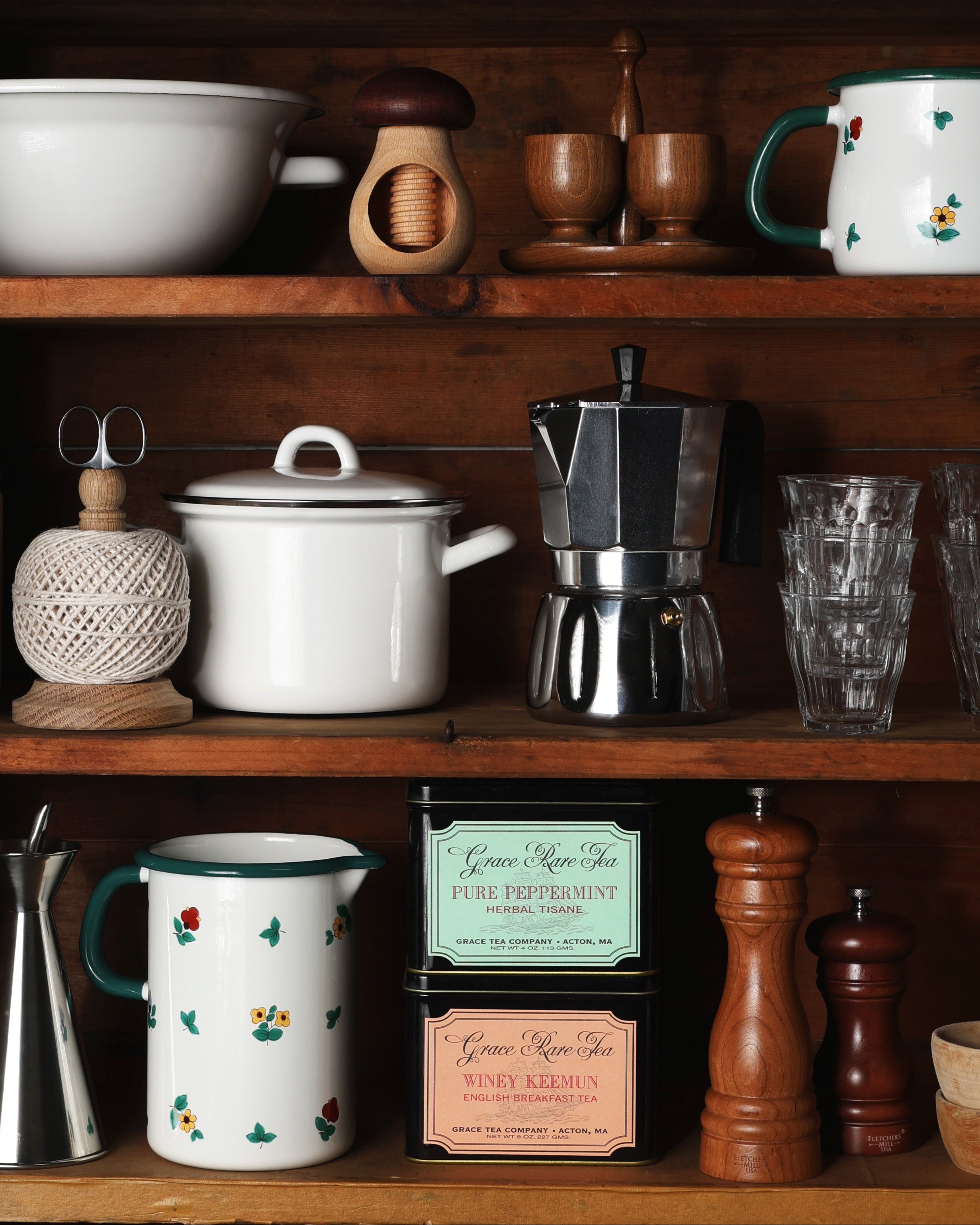 Cookware and drinkware on wooden shelves.