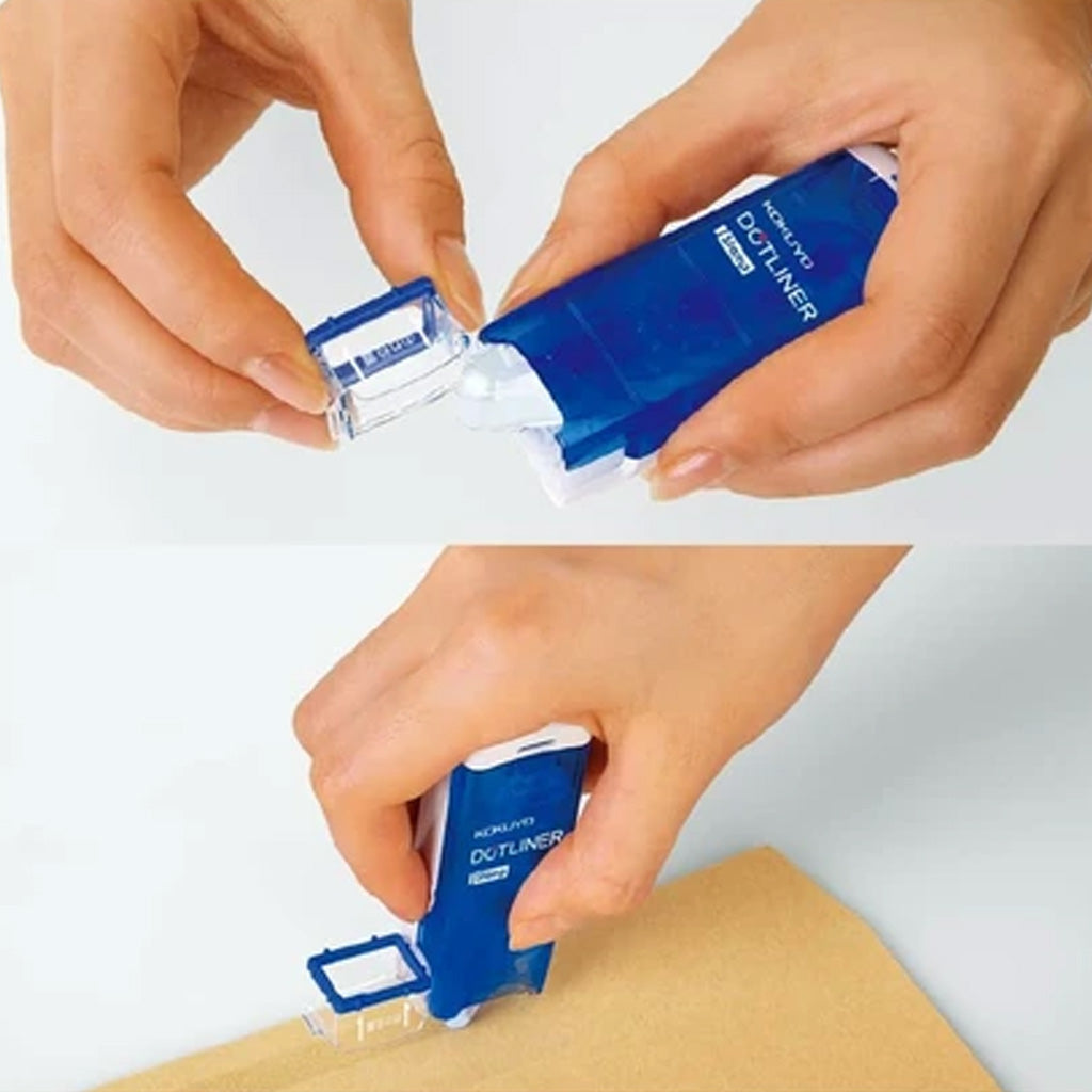 Hands opening and applying a patch of adhesive with Blue Kokuyo Dotliner Adhesive Roller Stamp with white logo onto brown paper