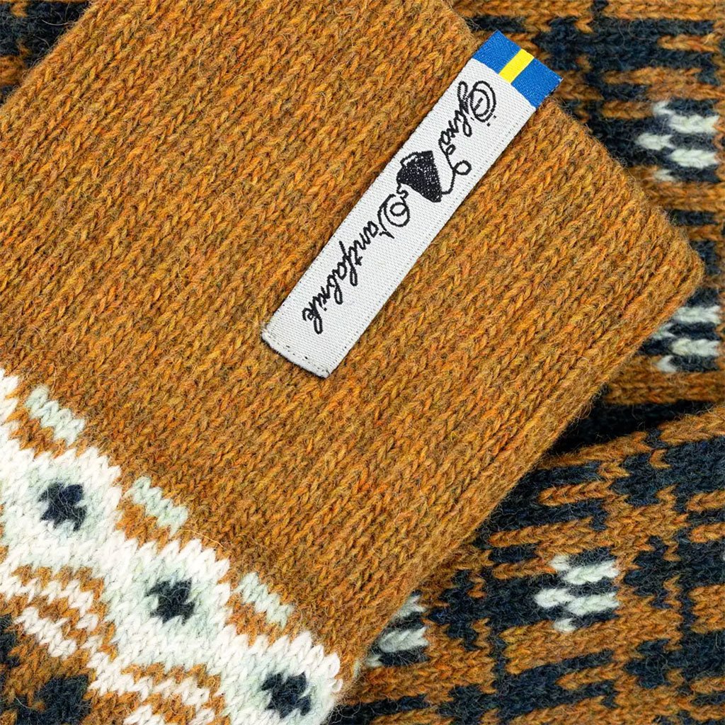 Close-up of yellow patterned socks with a brand label on a textured background