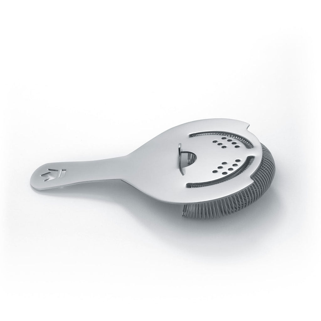 Metal Koriko cocktail strainer laying on white background