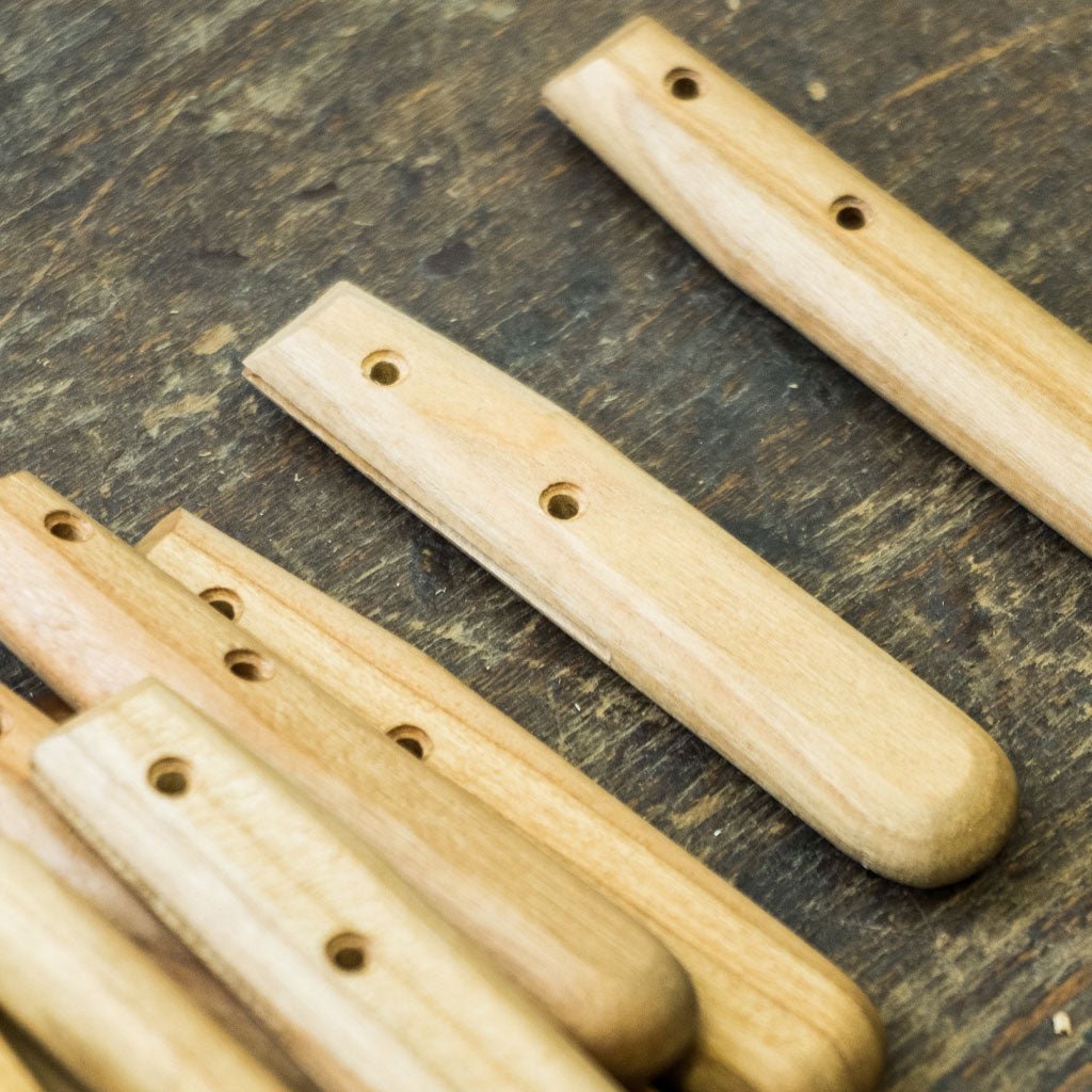 Wooden knife handles on a wooden surface