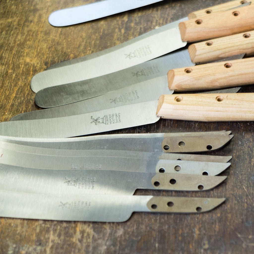 Set of knives with wooden handles on a wooden surface