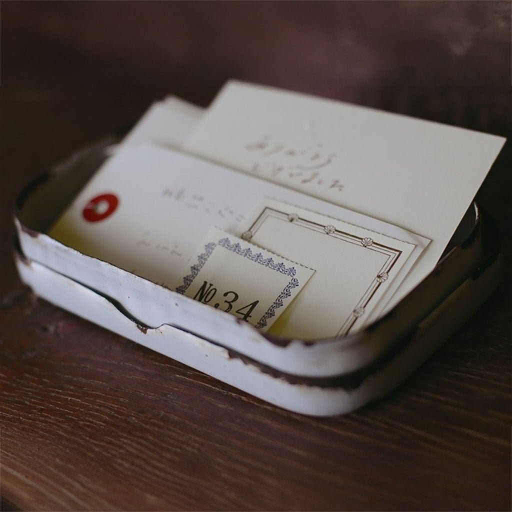 A metal tray holds letterpress book labels and other ephemera