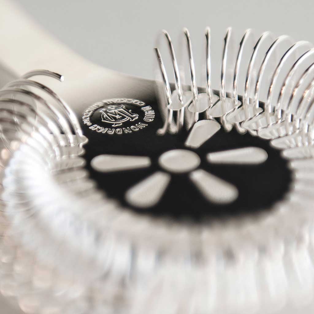 Close up of cocktail strainer on blurred gray background