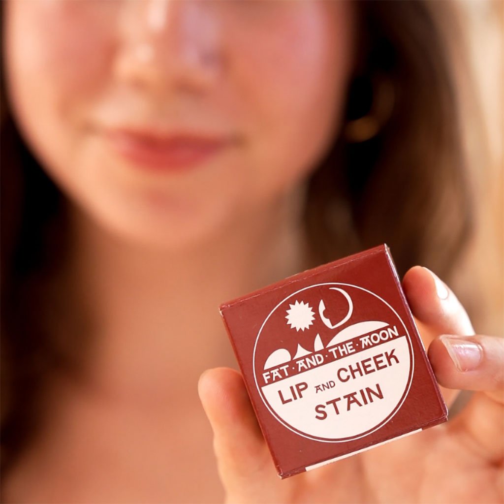 A person holding packaged lip and cheek stain