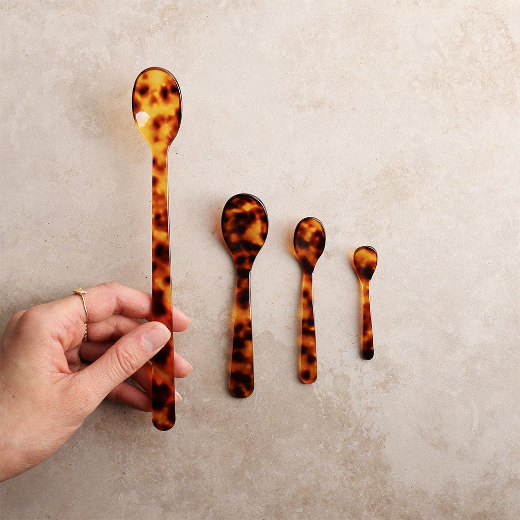 Set of tortoiseshell patterned spoons on a neutral background
