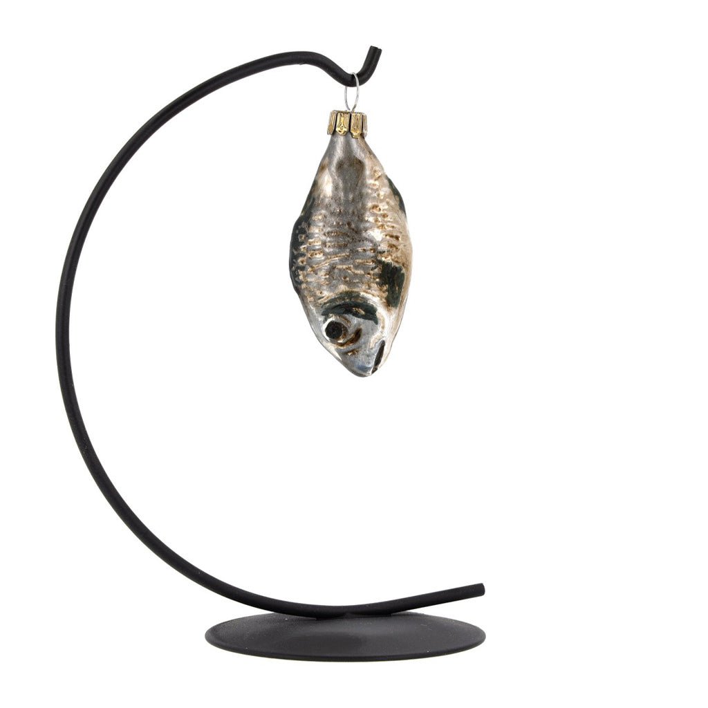 A glass carp ornament hung on black display piece.