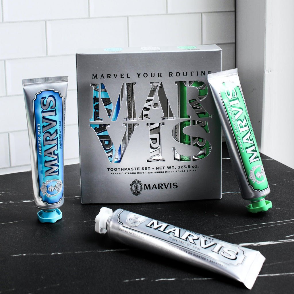 Marvis Toothpaste trio set on black counter.