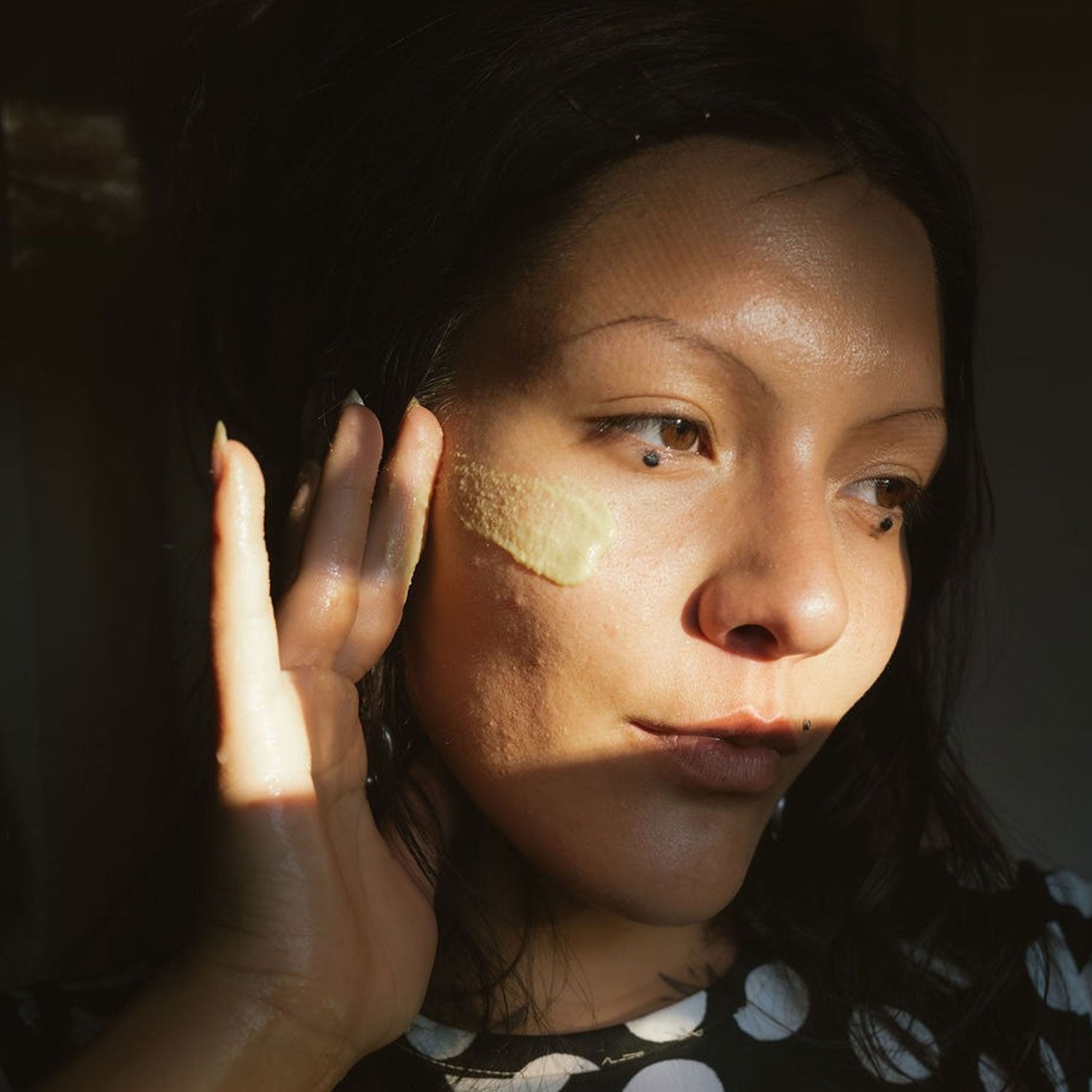 Person applying masa and olive face paste to their face