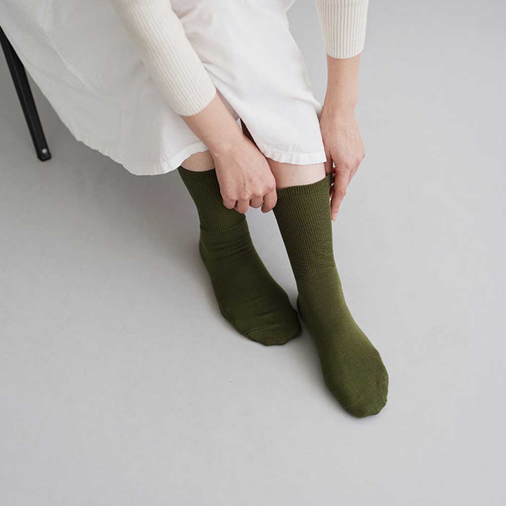Person wearing green socks on a plain background