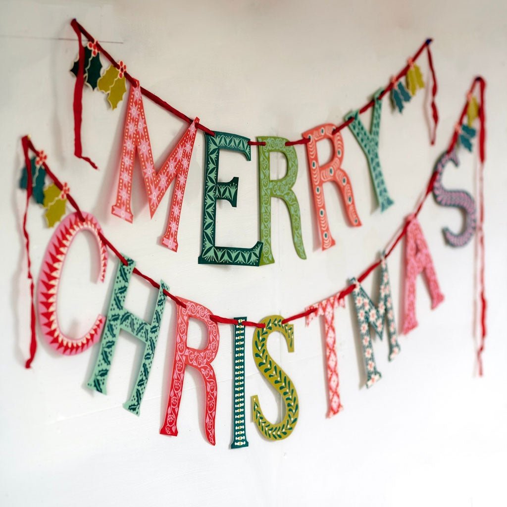 Colorful merry christmas banner with patterned letters hung on a wall