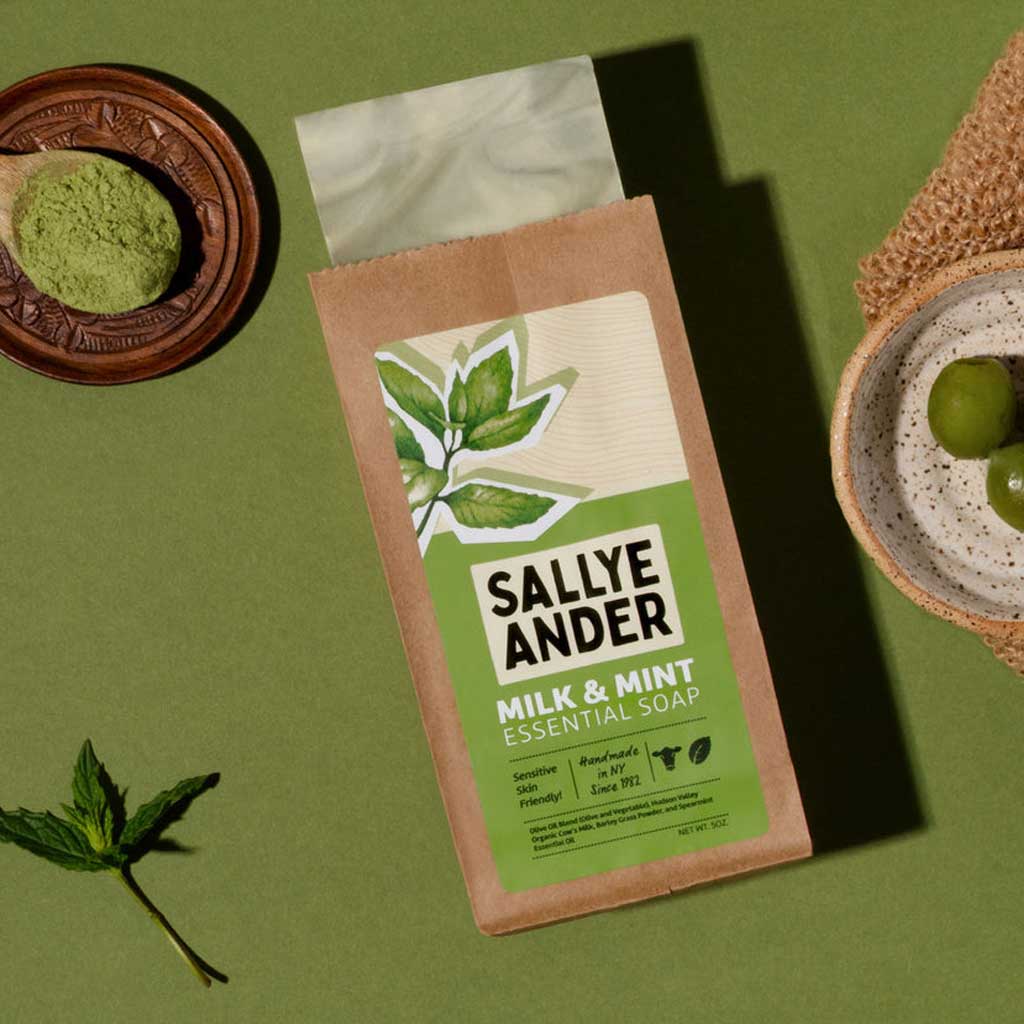 Sallye Ander Milk & Mint Essential Soap packaging on a green background with mint leaves.