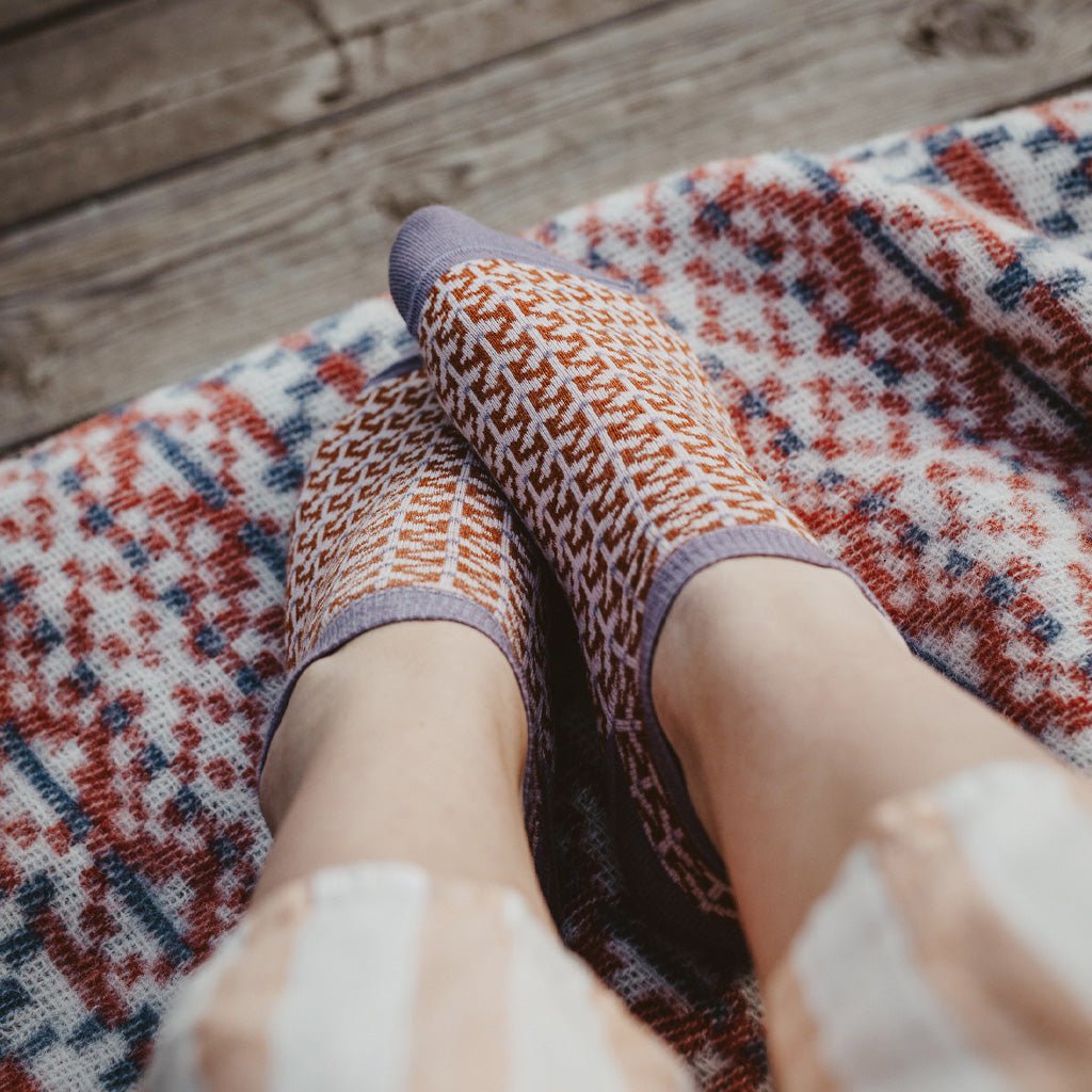 Model wearing pair of patterned wool socks.