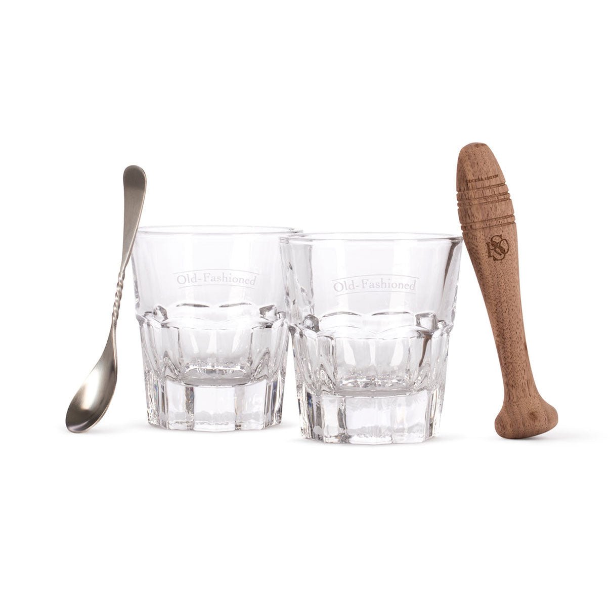 Two old fashioned glasses with wooden muddler and barspoon on white background