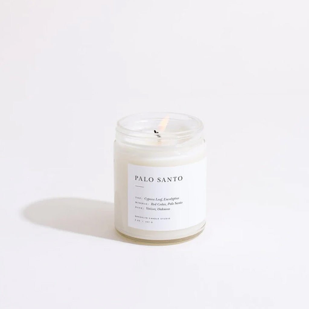 Glass candle with a white label on a light beige background