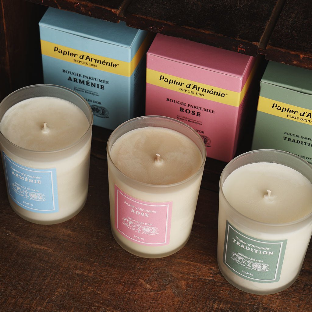 Three Papier d'Armenie candles in various scents on dark background