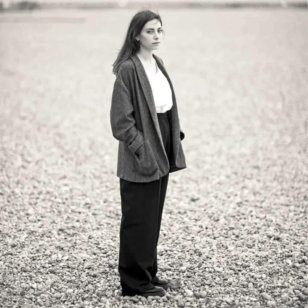Woman wearing merchant and mills sewn clothing on rocky beach