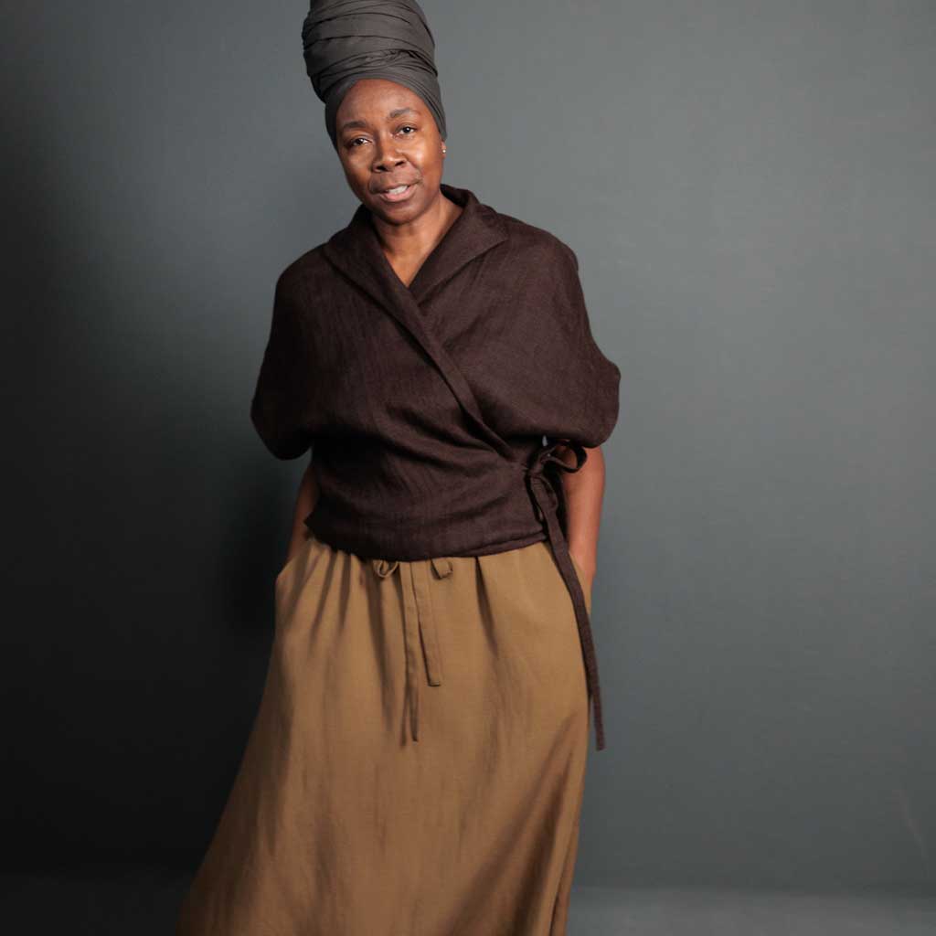 Woman wearing merchant and mills sewn clothing against dark background