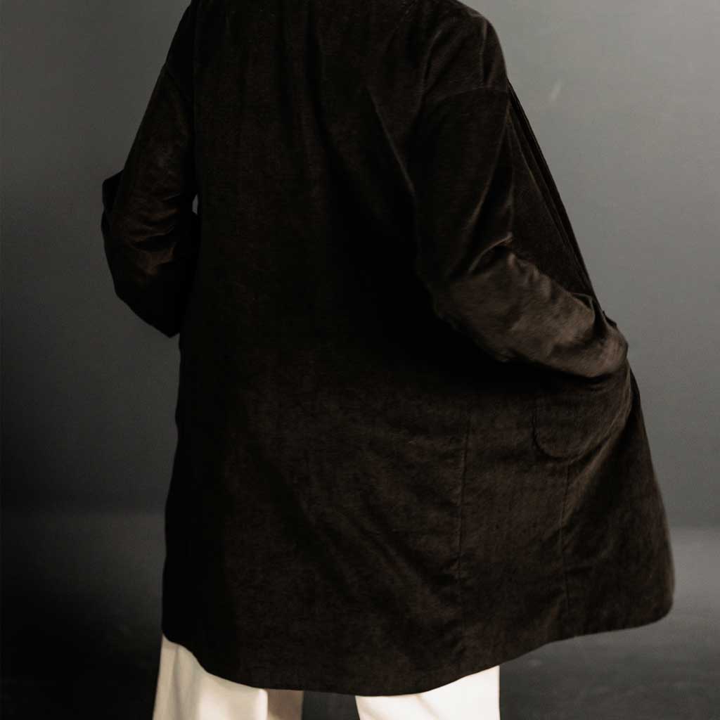 Woman wearing merchant and mills sewn clothing against dark background