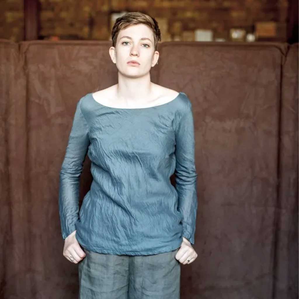 Woman wearing merchant and mills sewn clothing against dark background