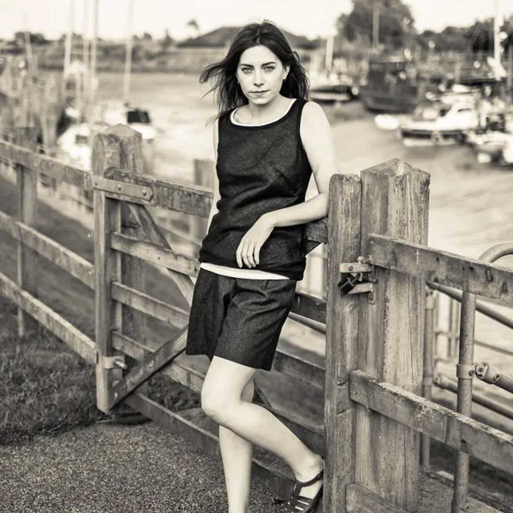 Woman wearing merchant and mills sewn clothing against boat dock background
