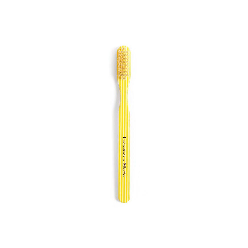 Yellow striped toothbrush on white background