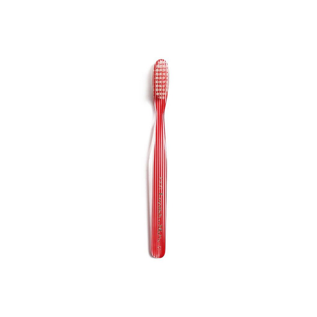 Red and clear striped toothbrush on white background