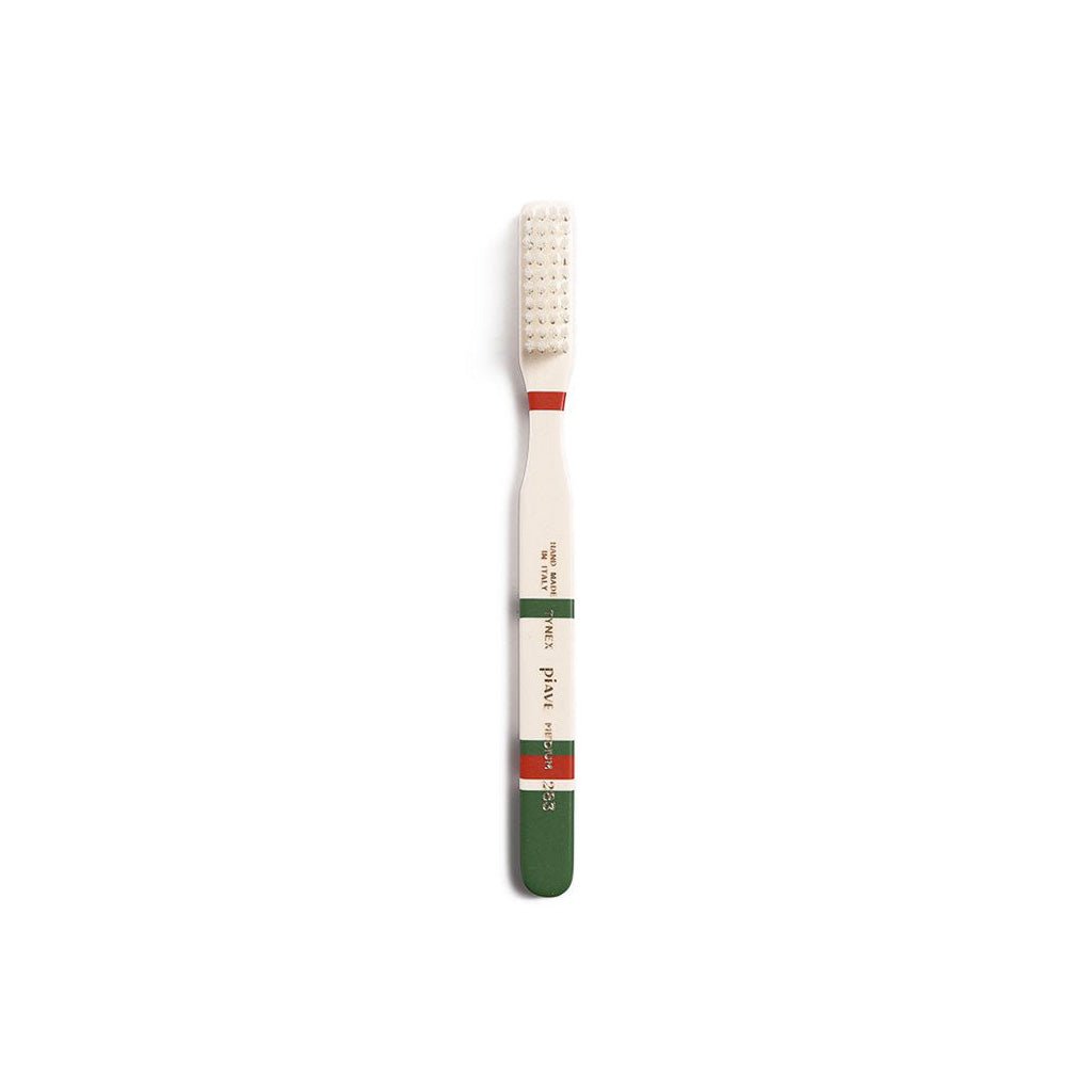 Pine green and cream toothbrush on white background