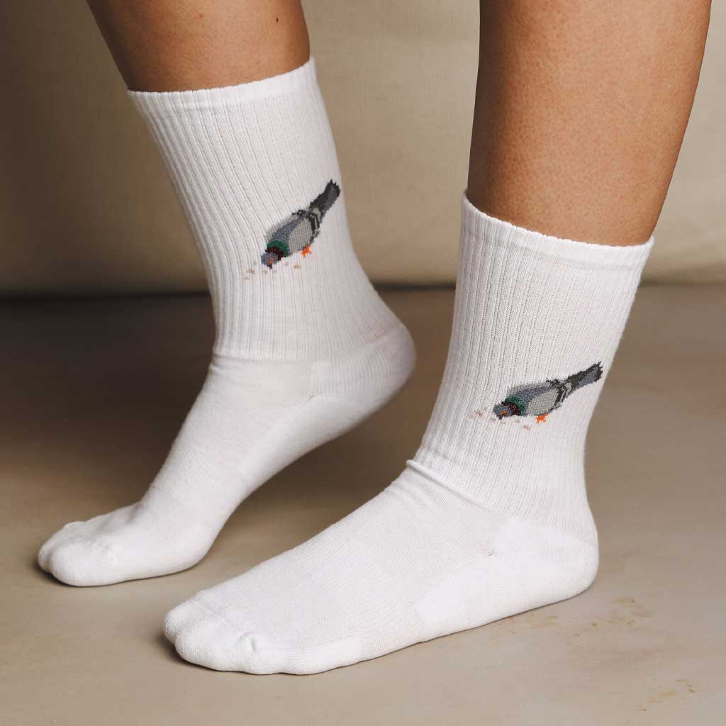 White socks with pigeon design worn by a person on a beige background