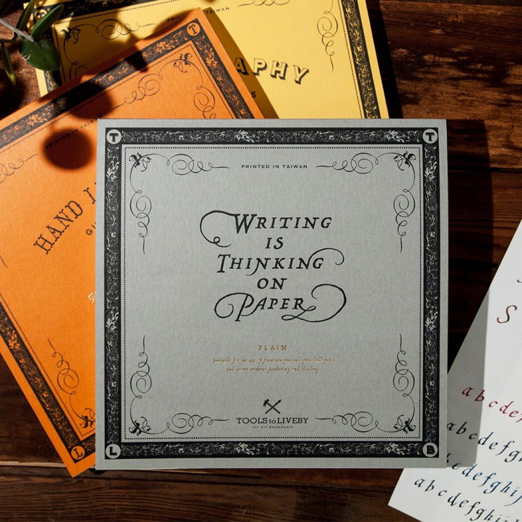 Three Tools to Liveby writing guidebooks in gray, orange, and yellow on wooden table