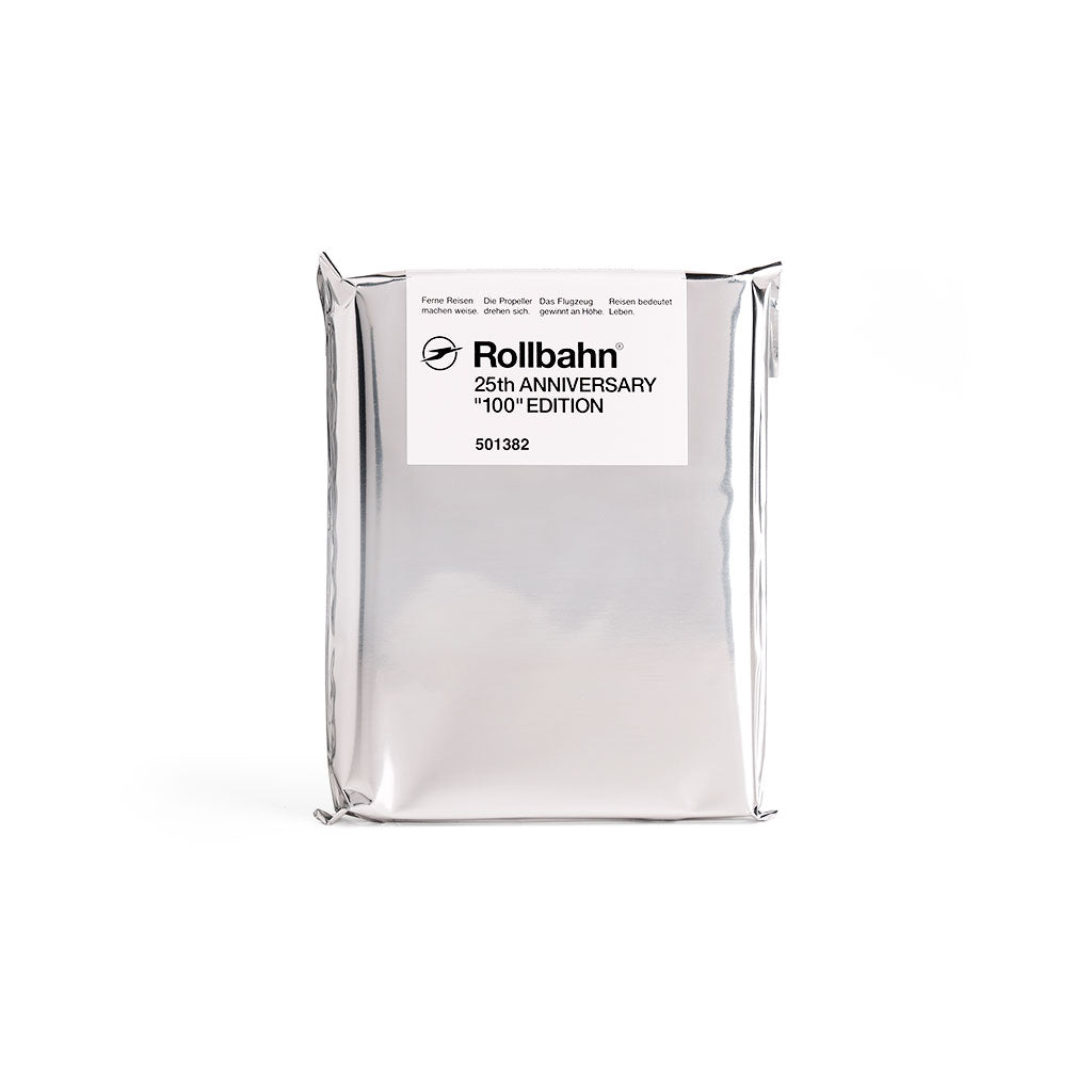 A silver foil package with a white label reading 'Rollbahn 25th Anniversary 100th Edition' on a plain white background.