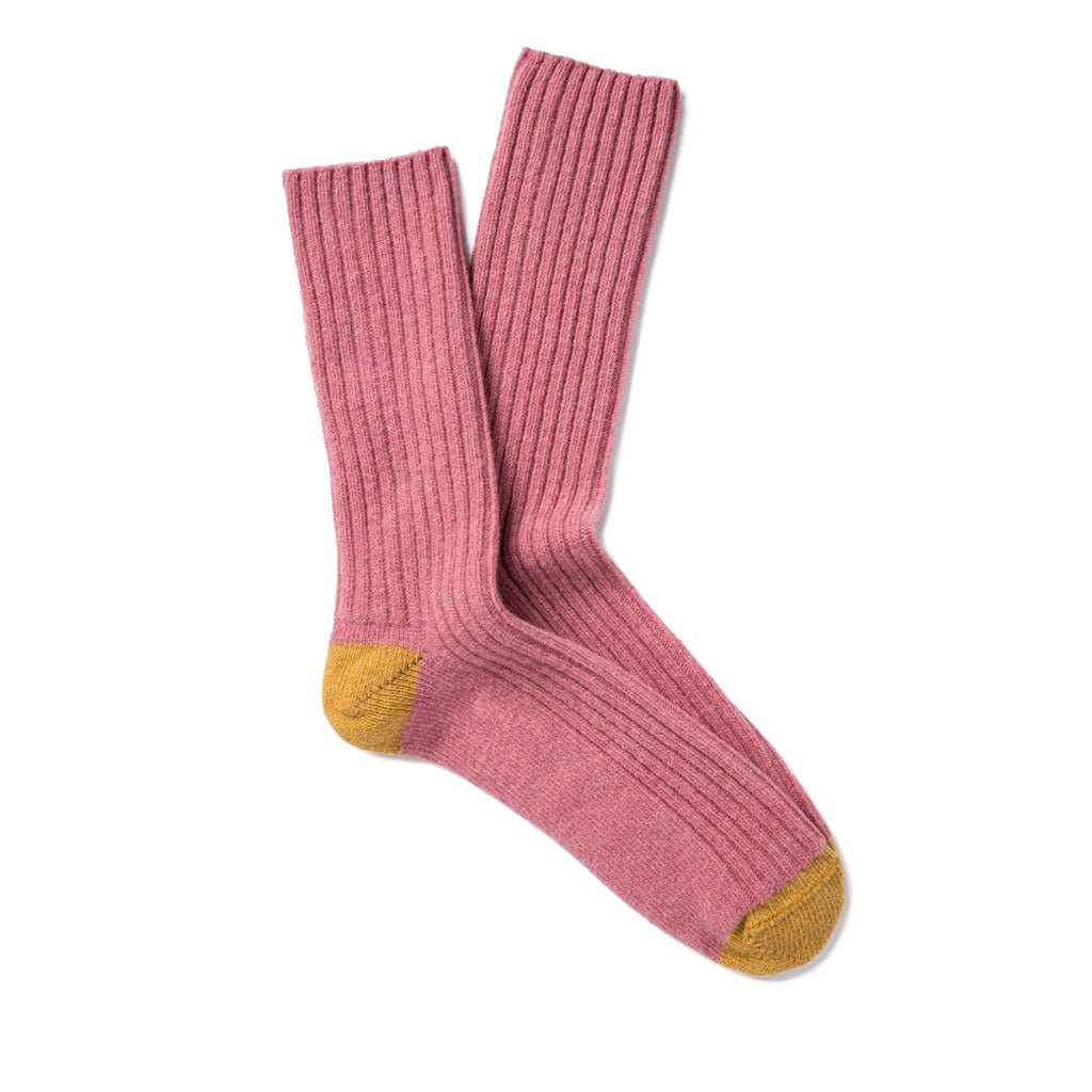 Pair of pink wool socks with yellow toes and heels.