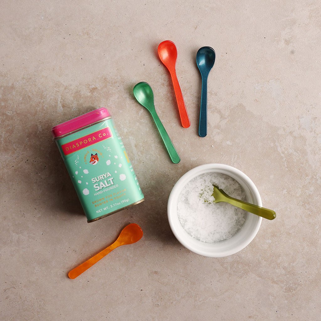 Surya Salt canister with colorful spoons and a bowl of salt on a beige surface