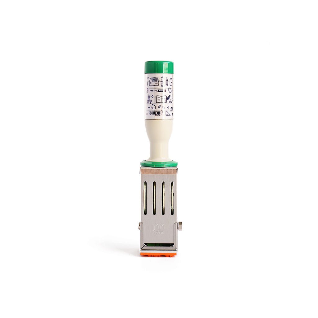 A medium rotary date stamp with a white handle and green accents, featuring Japanese text on the handle, as well as tiny illustrations of desktop essentials.