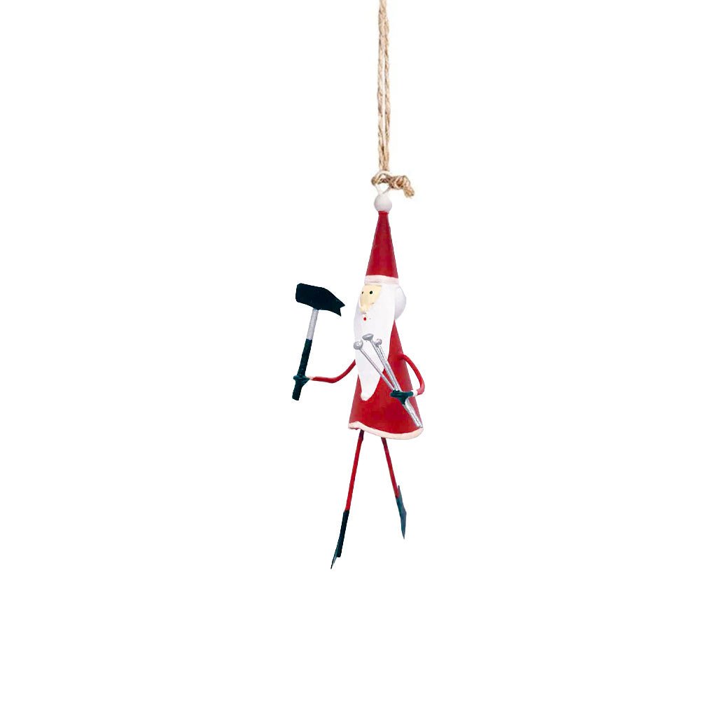 A Santa ornament holding a hammer and nails, hanging on a twine string.