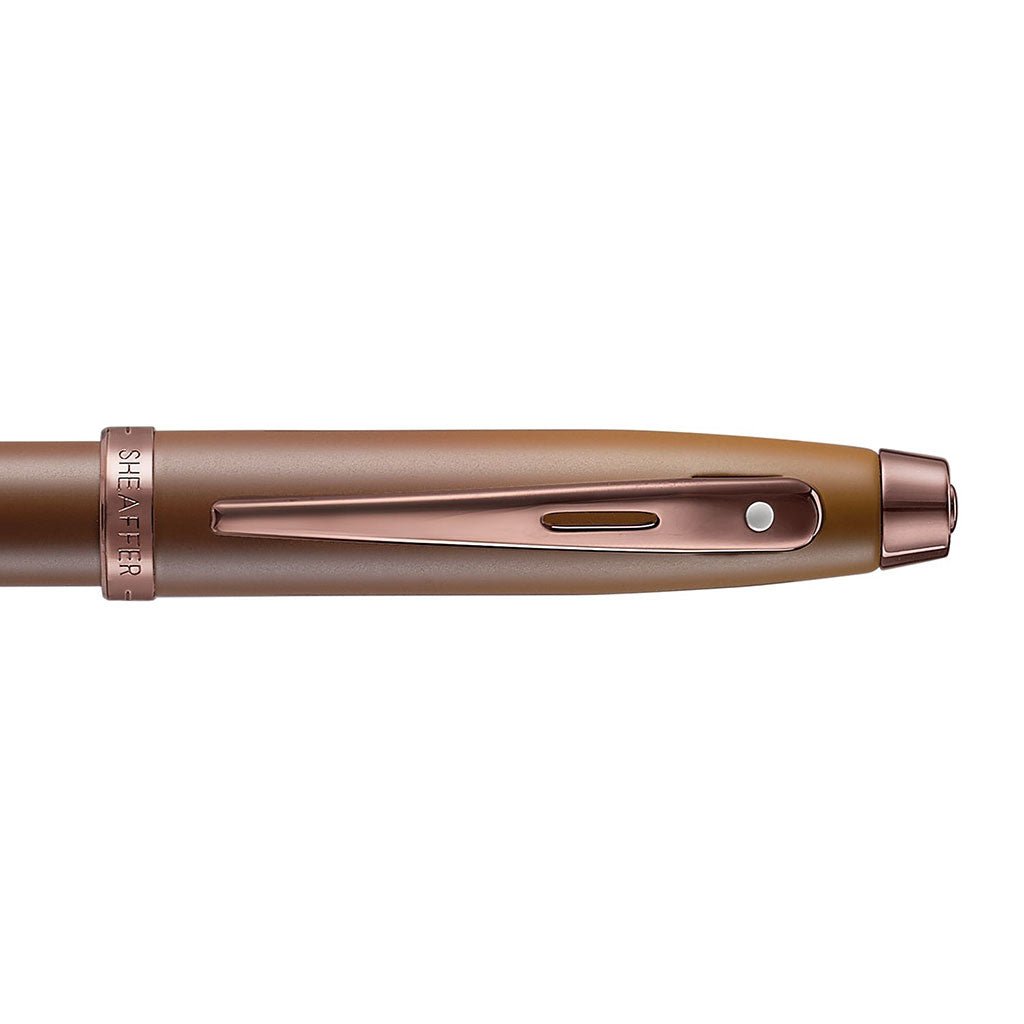 Cap of Brown ballpoint pen with rose gold accents on white background