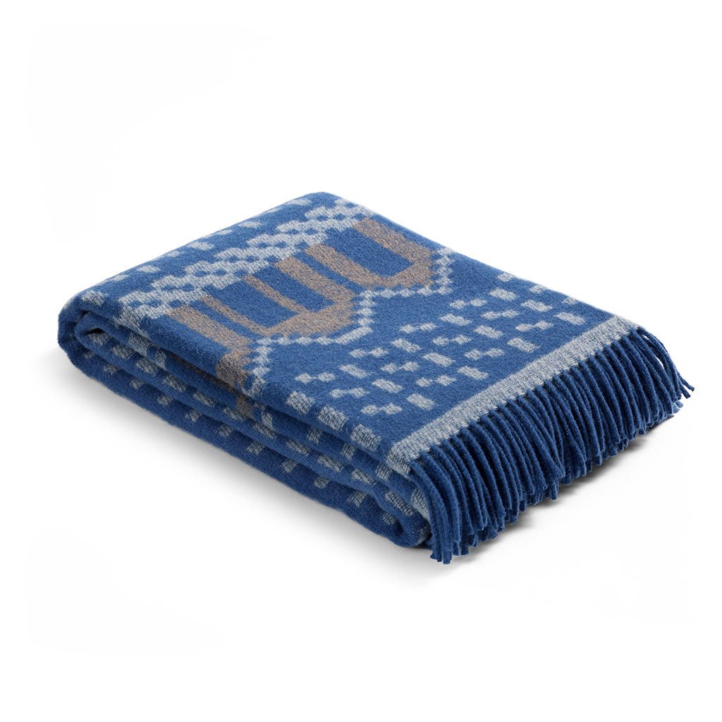 Folded blue blanket with geometric pattern on a white background
