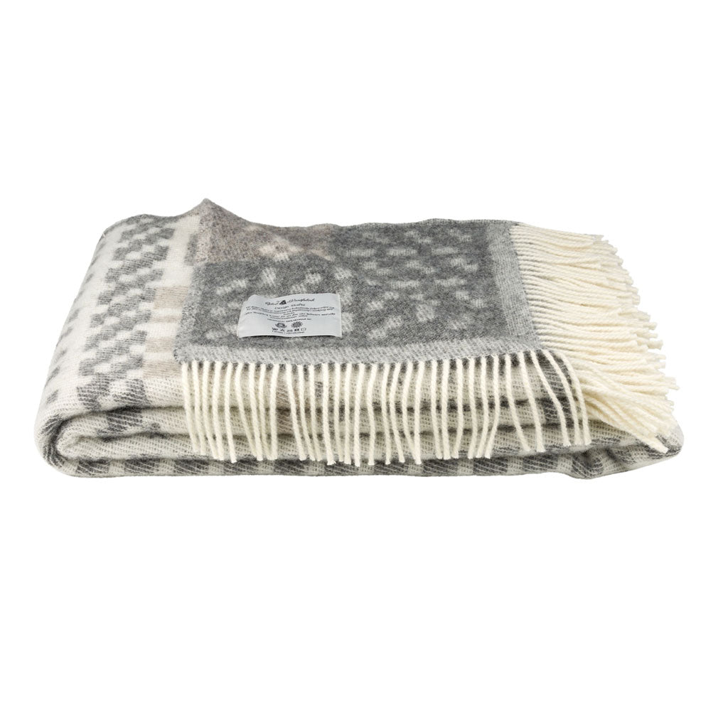 Folded gray and white checkered blanket with fringes on a white background