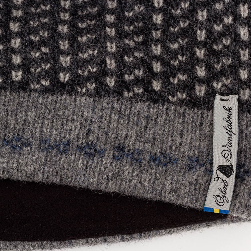 Close-up of a textured fabric with a brand tag on a black background