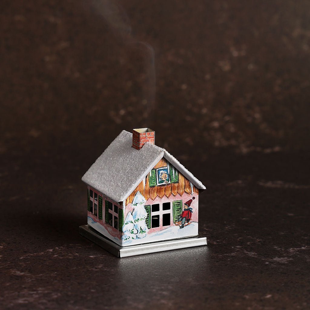 Small metal incense smoker cottage house on dark background