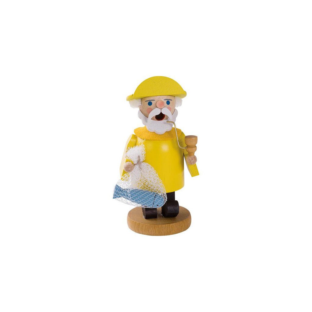 A small wooden incense burner of a man wearing a yellow raincoat and yellow hat, holding a blue fish and pipe, standing on a round wooden base against a plain white background.