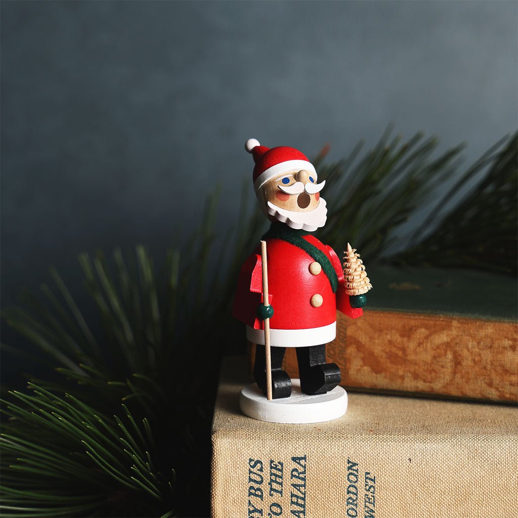 Santa Claus incense burner figurine holding a staff on a dark background