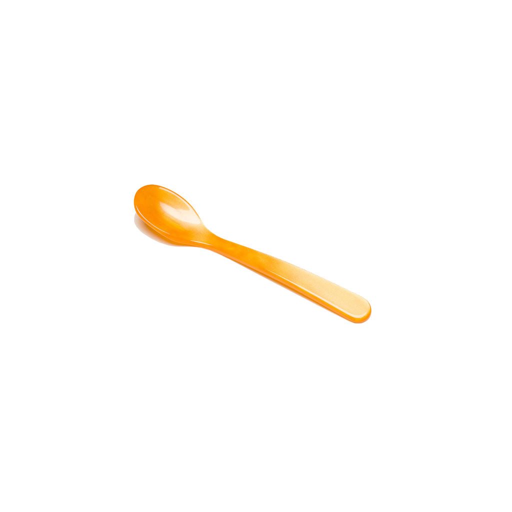 Orange acrylic salt spoon on white background