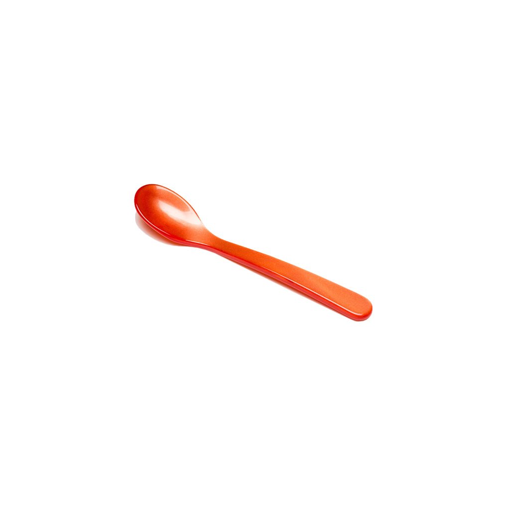 Coral red acrylic salt spoon on white background